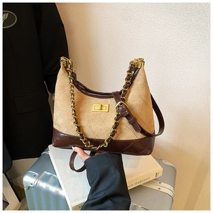 Detail view of retro camel suede crossbody bag with rhombus stitching and gold twist lock