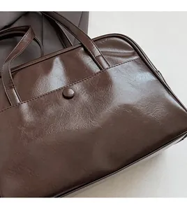 Detail of dark brown retro tote bag showing smooth PU leather texture and front pocket