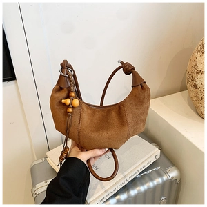 Brown suede crescent moon bag with bohemian fringe detail and wooden bead charm