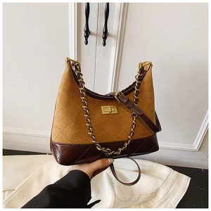 Close-up of quilted leather patchwork and golden chain strap on crossbody bag