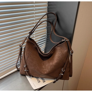 Detail of vintage brown oversized tote bag with silver metal ring hardware and retro oil wax finish