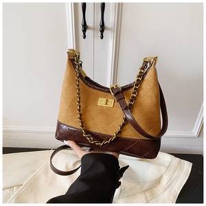 Detail of vintage patchwork crossbody bag featuring quilted brown faux suede and gold chain