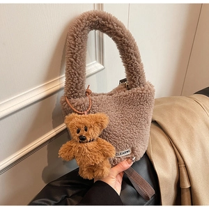 Détail du sac seau en polaire marron foncé avec charm d'ours en peluche et étiquette