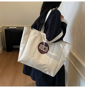 Side view of a large white PU leather tote bag with red POCO logo on a female model
