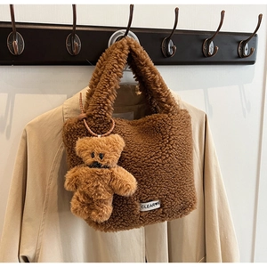 Détail du sac seau en peluche marron avec pendentif ours et étiquette blanche cousue