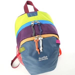 Detail of multi-layer zipper compartments on a colorful nylon hiking backpack