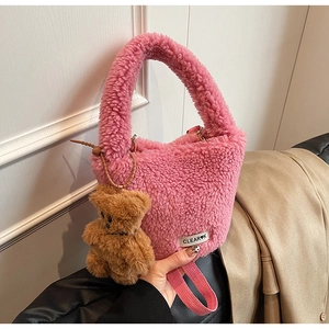 Détail du sac seau rose en polaire avec breloque ours et étiquette de logo chic
