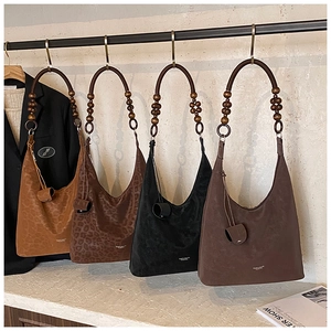 Vue détaillée des sacs hobo bohèmes avec imprimé léopard et poignées en bois