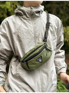 Detail der Outdoor-Umhängetasche mit grünem Karostoff und verstellbarem Gurt