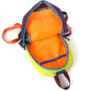 Detail view of colorful hiking backpack with spacious orange interior and blue zippers