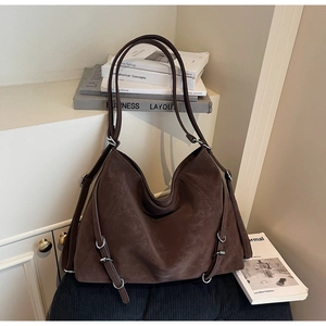 Macro view of brown vintage tote bag showing matte texture and silver metal ring buckle