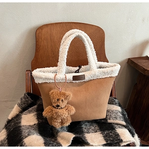 Detail of winter khaki suede tote bag with white fleece trim and cute bear charm
