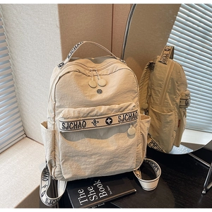 Detail of beige nylon backpack with SJCHAO logo straps and smooth rubber zipper pulls