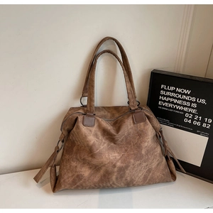 Détail du sac cabas rétro marron avec texture vintage et rivets métalliques chic