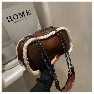 Macro detail of brown leather cross-body bag with white faux fur trim and chain strap