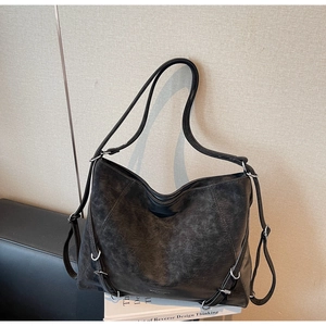 Detail of vintage washed leather texture and silver buckle on large black tote bag