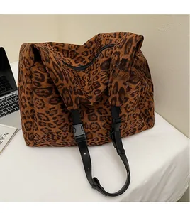 Close-up of leopard print tote bag featuring a black adjustable nylon shoulder strap