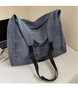 Detail of blue denim tote bag showing the smooth adjustable black nylon shoulder strap