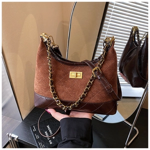 Close-up of brown suede crossbody bag with gold chain and quilted diamond pattern