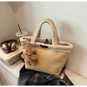 Detail of khaki faux shearling tote bag with a cute brown plush bear charm and leather logo