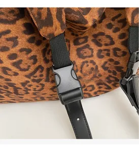 Detail of durable buckle and black webbing on leopard print faux suede tote bag