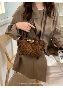 Leopard print bucket bag with brown leather handles and metal clasp lock detail