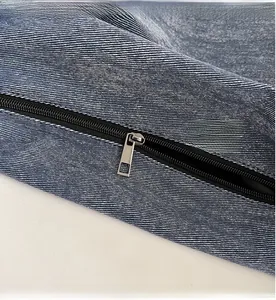 Detail of smooth metal zipper and premium blue denim fabric texture on tote bag
