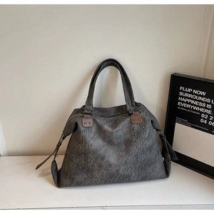 Détails de sac cabas gris orné de rivets argentés et de finitions en cuir marron