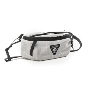 Detail of light gray plaid chest bag with adjustable strap and front logo patch