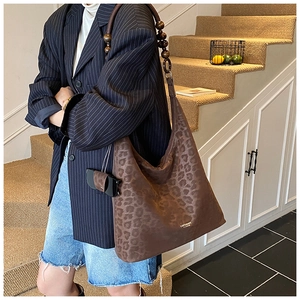 Détail du sac hobo rétro à imprimé léopard avec de grandes perles en bois sur la bandoulière