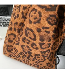Detail of leopard print faux suede fabric texture with black buckle on crossbody bag