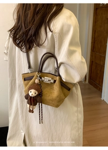 Detail showing faux suede pleated bucket bag with leather handle and cute bear charm