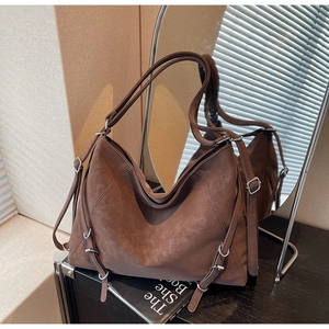 Detail of dark brown vintage hobo bag with silver metal eyelets and adjustable strap
