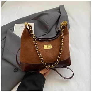 Detail of suede and leather patchwork crossbody bag with quilted pattern and gold twist lock