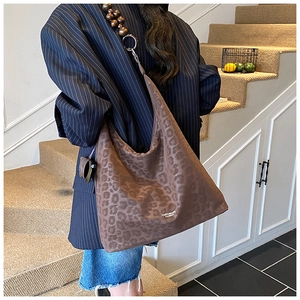 Close-up of brown leopard print hobo bag with unique wooden bead strap detail