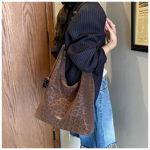 Détail d'un grand sac cabas imprimé léopard avec logo de marque et motif style vintage