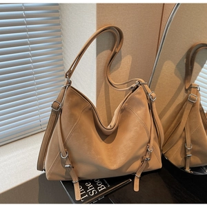 Detail of light brown faux leather tote bag with decorative long straps and buckle