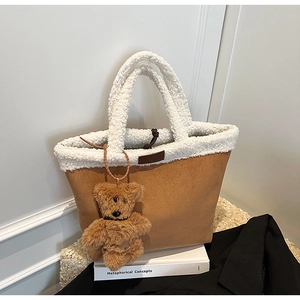 Detail of faux suede tote bag featuring plush teddy fur trim and a bear charm accessory