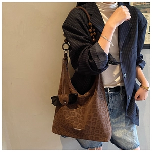 Detail of leopard print hobo bag with distinctive wooden bead shoulder strap
