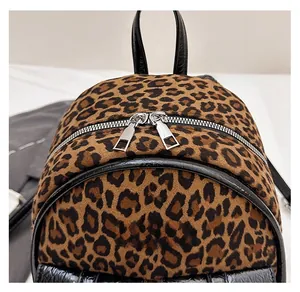 Gros plan du sac à dos léopard avec doubles fermetures éclair argentées et logo métal