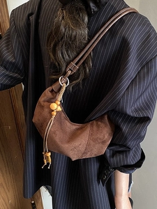 Brown frosted suede crescent bag with wooden bead tassel and crossbody strap for women