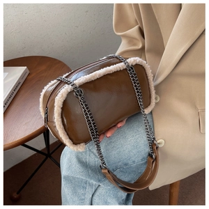 Close-up of brown faux leather shoulder bag with white fleece trim and metal chain strap