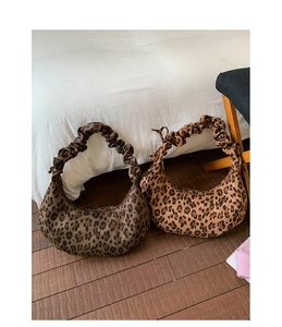 Detail view of crescent leopard print bags with ruffled cloud-like handles in two colors
