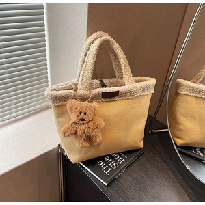 Detail of yellow fuzzy tote bag with soft white faux fur trim and cute bear charm pendant
