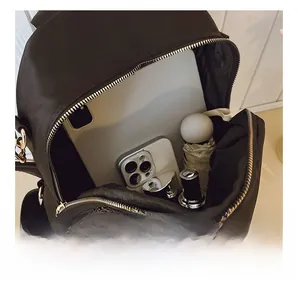 Detail view of large capacity black oxford backpack interior with tablet and daily items