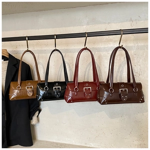 Détail de quatre sacs sous le bras en cuir brillant avec clous métalliques et boucles en couleurs
