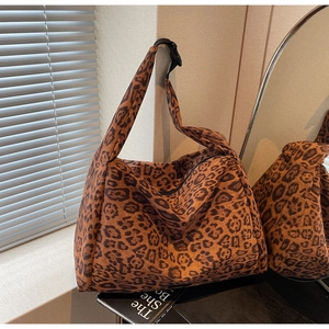 Macro view of leopard print tote bag with black plastic buckle and suede texture
