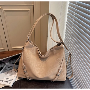 Macro view of light brown tote bag featuring metallic rings and textured faux leather