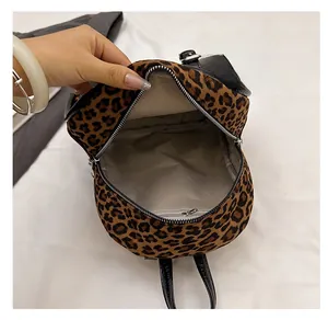 Vue interne montrant la doublure en tissu gris et la poche zippée du sac à dos léopard
