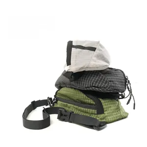Detailed stack of three ripstop nylon chest bags in beige, black, and dark green colors